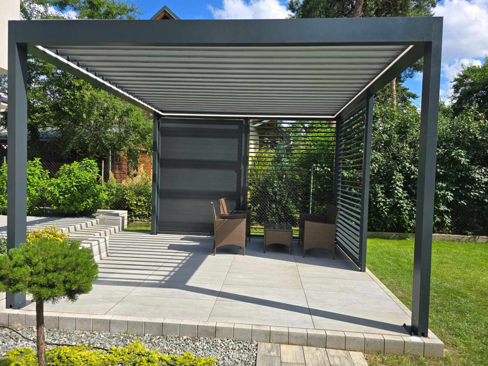 Pergola żaluzjowa na taras wolnostojąca w ogrodzie z aluminiowymi shuttersami i roletą ZIP – SuperPergole Warszawa