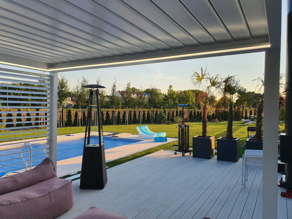 Nowoczesna pergola żaluzjowa na taras z oświetleniem LED i przesłonami bocznymi przy ogrodzie z basenem – SuperPergole Warszawa