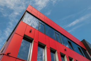 Kasetony elewacyjne SKRIN BP2 w intensywnym czerwonym kolorze na nowoczesnej fasadzie budynku