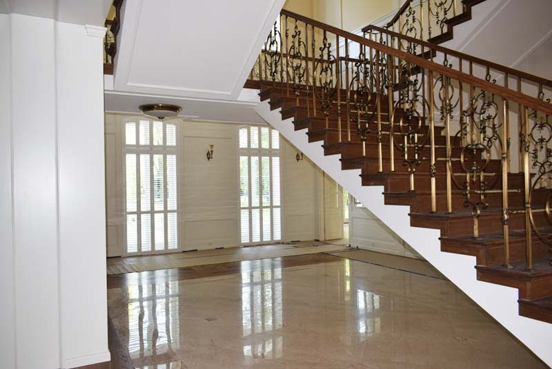 Klatka schodowa z wysokimi oknami i białymi okiennicami shutters wewnętrznymi