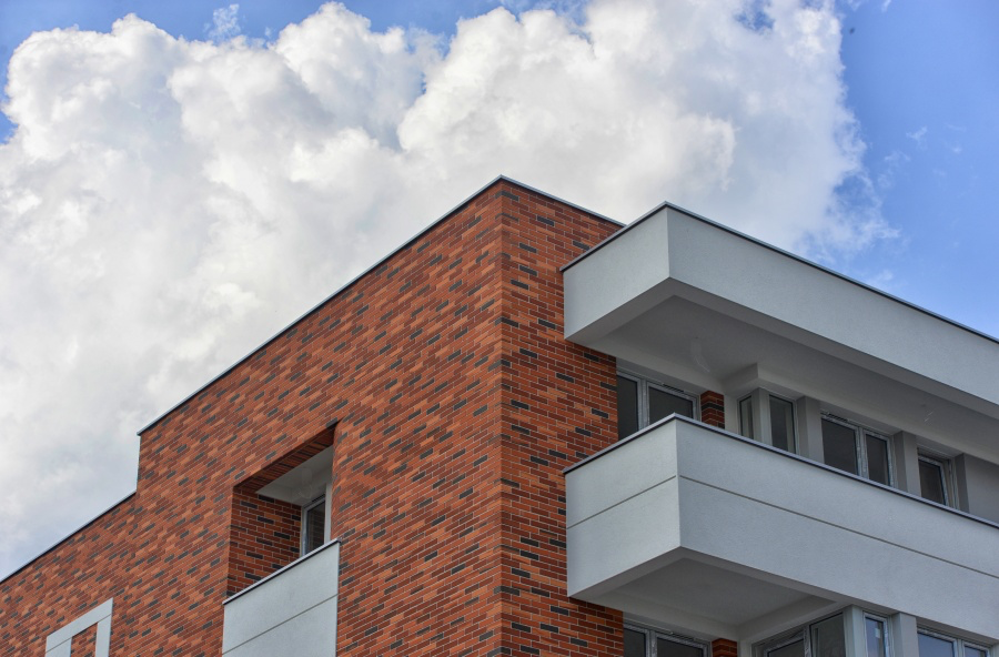 Płytki elastyczne na elewacji budynku mieszkalnego w fakturze czerwonej i czarnej cegły PromaDekor CE