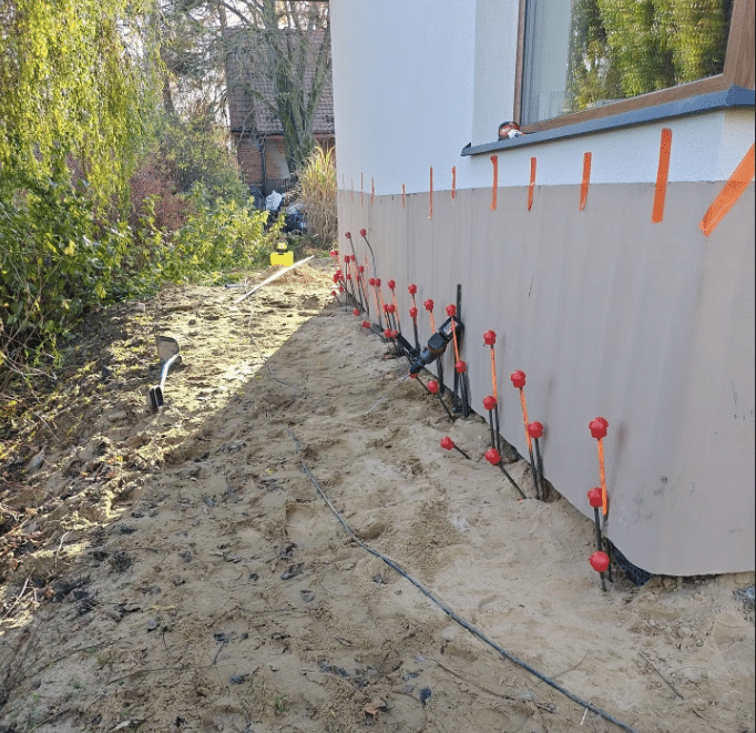 Punkty iniekcyjne rozmieszczone wzdłuż fundamentu przed wzmocnieniem podłoża geopolimerem