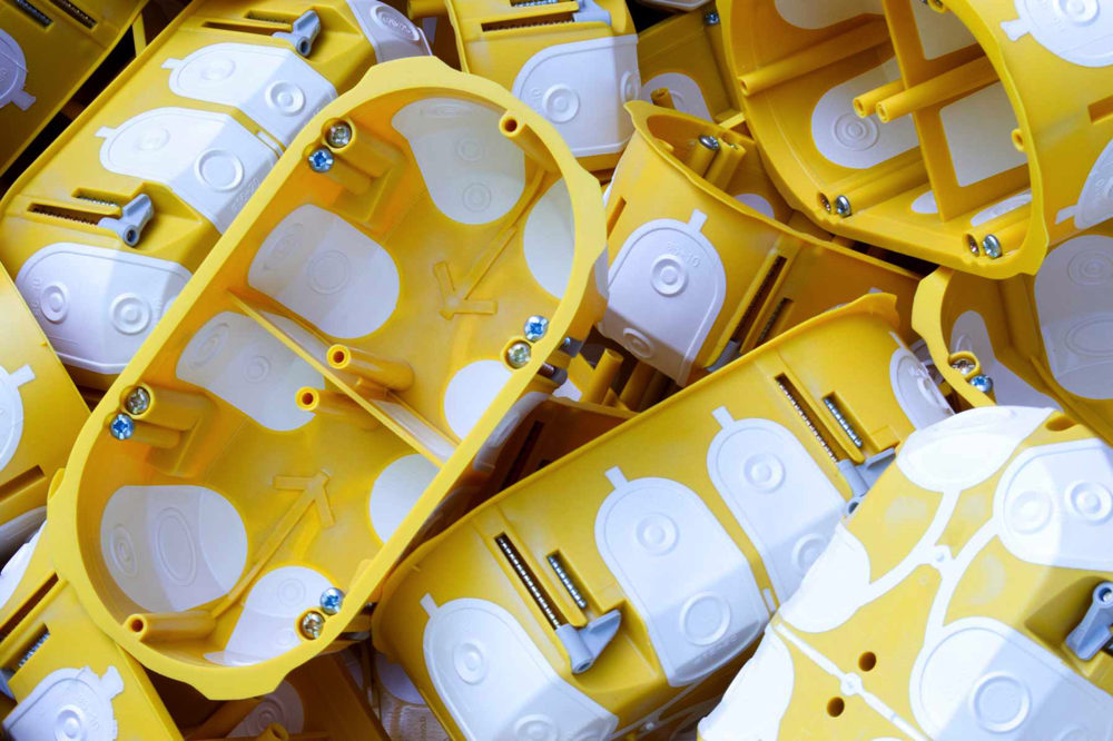 Żółte puszki dwukomponentowe do domów szkieletowych KOPOS, w których klasyczne wyłamywane wloty zastąpiono szczelnymi elastycznymi membranami.