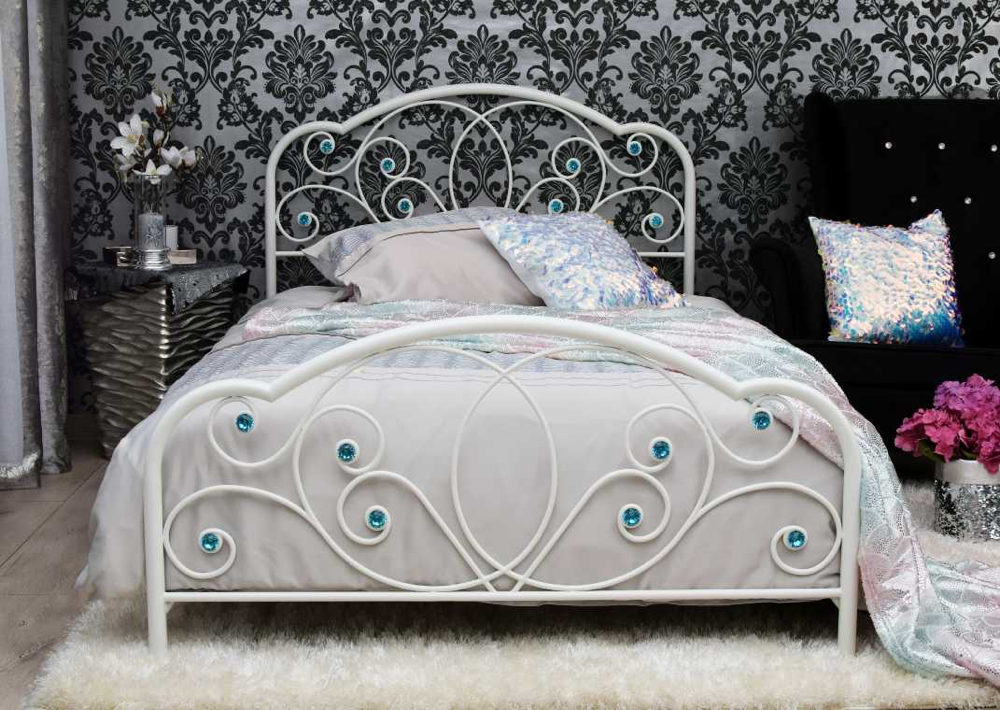 Białe metalowe łóżko z ozdobnym wezgłowiem i dekoracyjnymi detalami w eleganckiej sypialni.