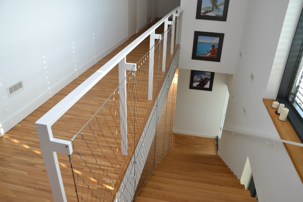 balustrada z siatki nierdzewnej na antresoli – nowoczesne wnętrze z drewnianą podłogą