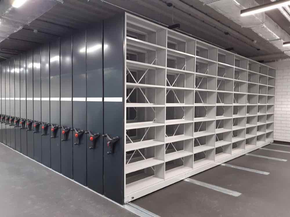 Rozbudowany system regałów przesuwnych do archiwum z torowiskiem, półkami i mechanizmem jezdnym