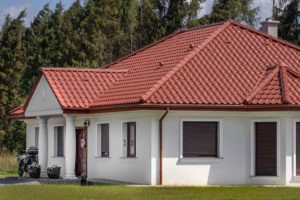 Dach domu jednorodzinnego pokryty ceramiczną dachówką swissporTON TITANIA w kolorze miedzianej angoby.
