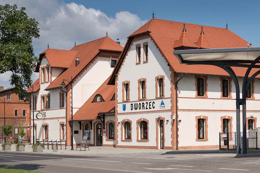 Zabytkowy budynek dworca z dachem pokrytym ceramiczną dachówką swissporTON w klasycznym, ceglastym kolorze.