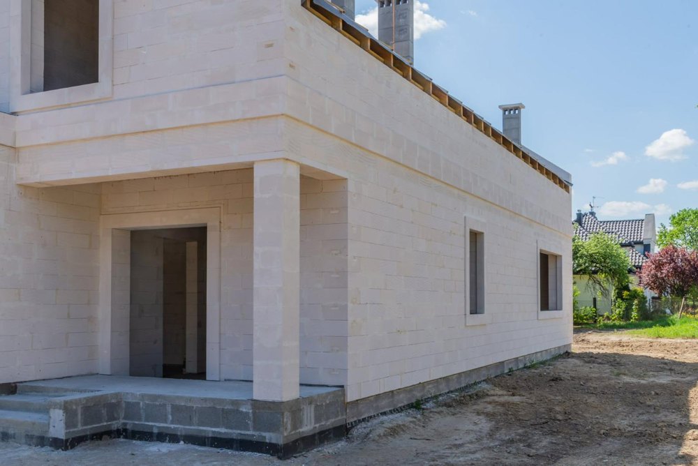 10. Narożnik domu w stanie surowym wzniesionego ze ścian jednowarstwowych z betonu komórkowego Ytong, bez warstwy ocieplenia.