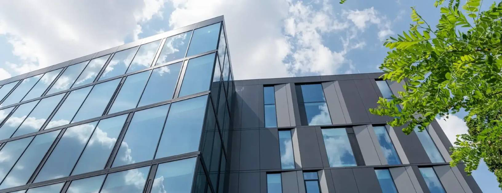 Nowoczesna fasada aluminiowo-szklana wspierająca doświetlenie naturalne i efektywność energetyczną budynku.