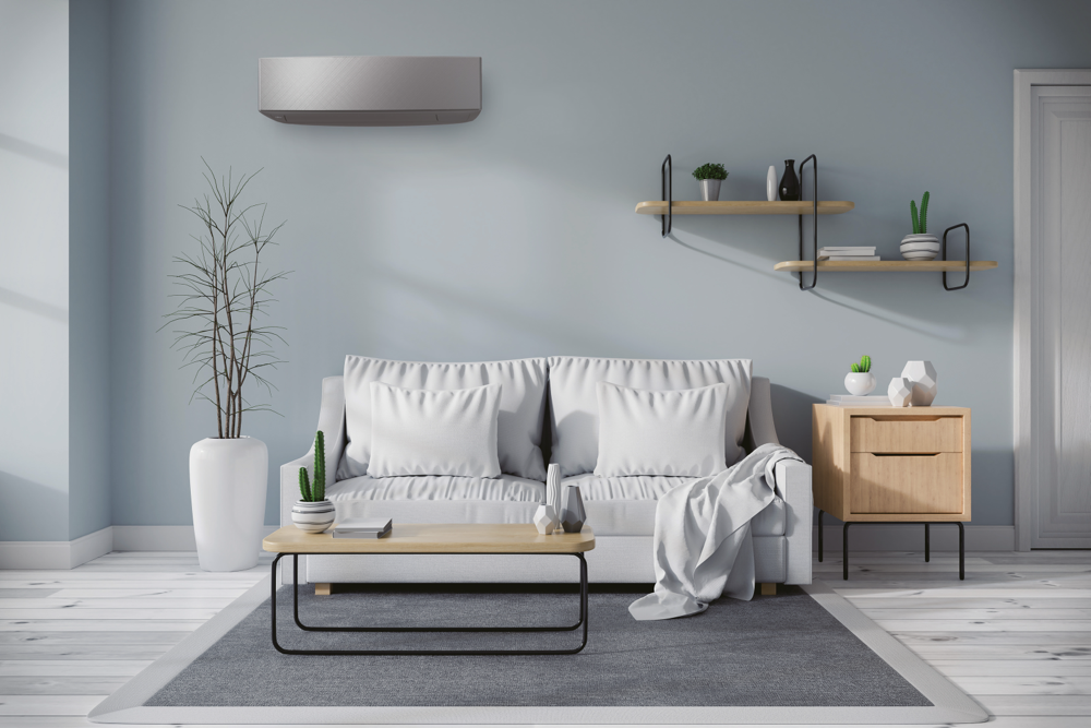 Klimatyzator Fujitsu z Serii Design KETF-B w szarej obudowie zamontowany nad sofą w jasnym salonie.