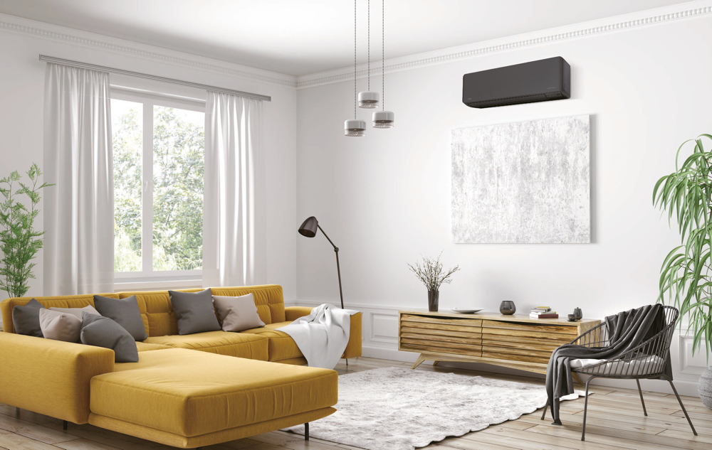 Czarny klimatyzator Fujitsu KMCG-B soft black w eleganckim salonie z żółtą sofą i drewnianą komodą.