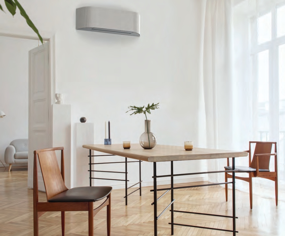 Jasny klimatyzator Toshiba HAORI zamontowany na ścianie w minimalistycznej jadalni.